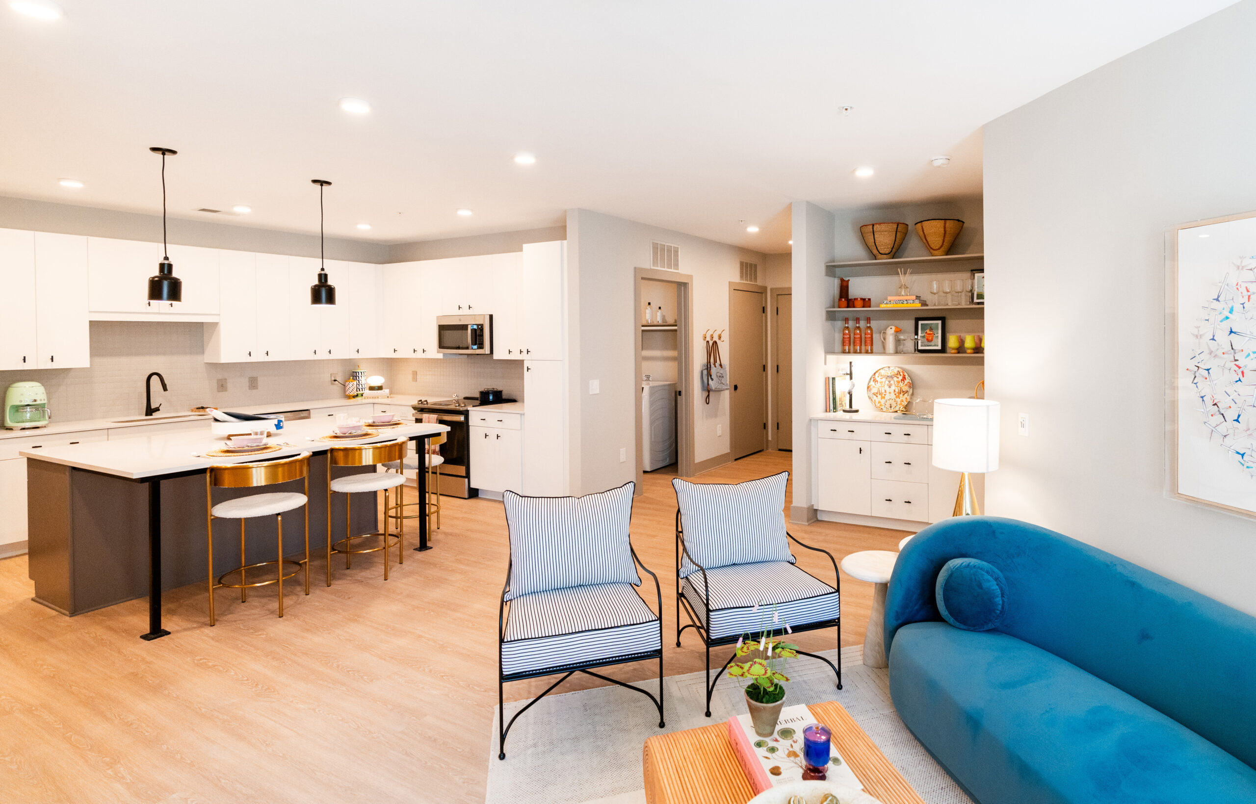 Furnished kitchen, living room, wet bar, and laundry room.